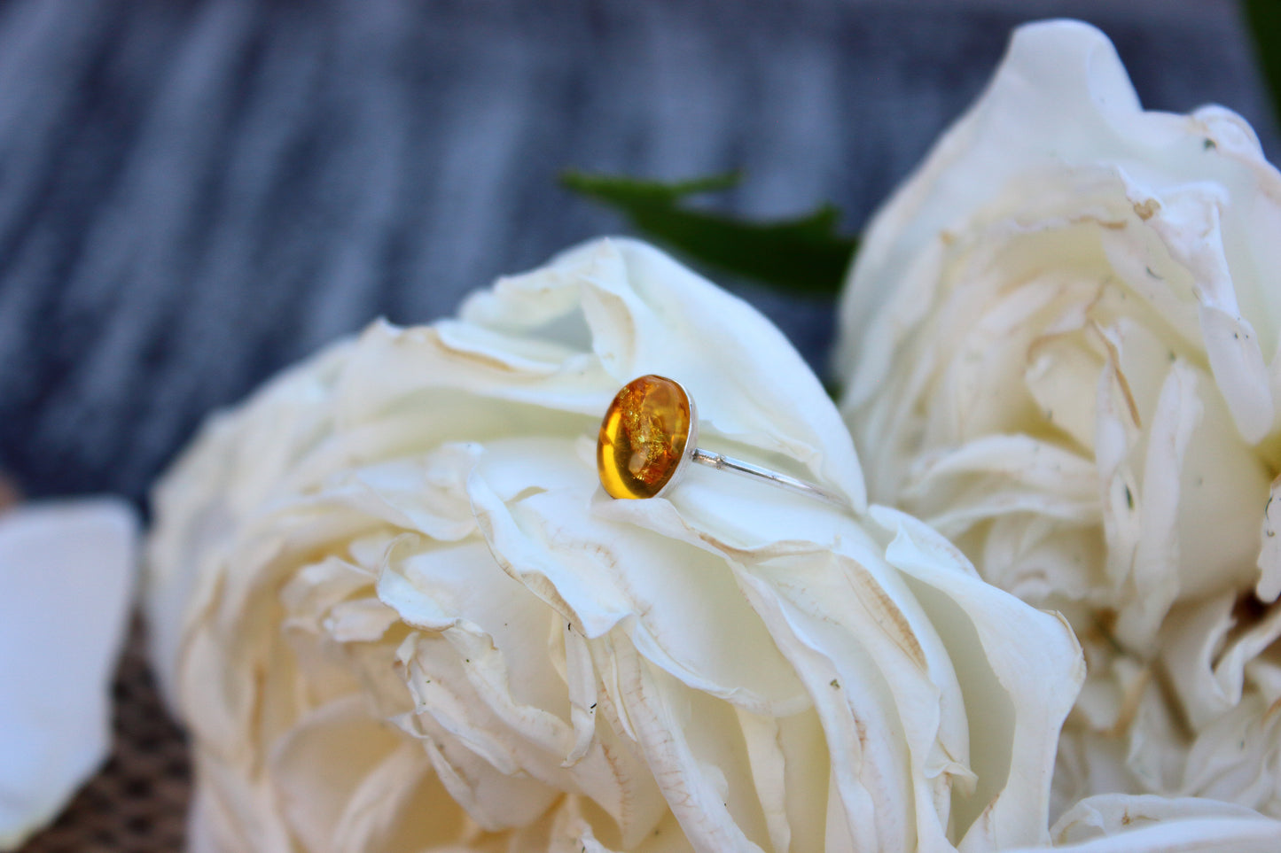 Close-up of a ring with a yellow gemstone on a white flower.