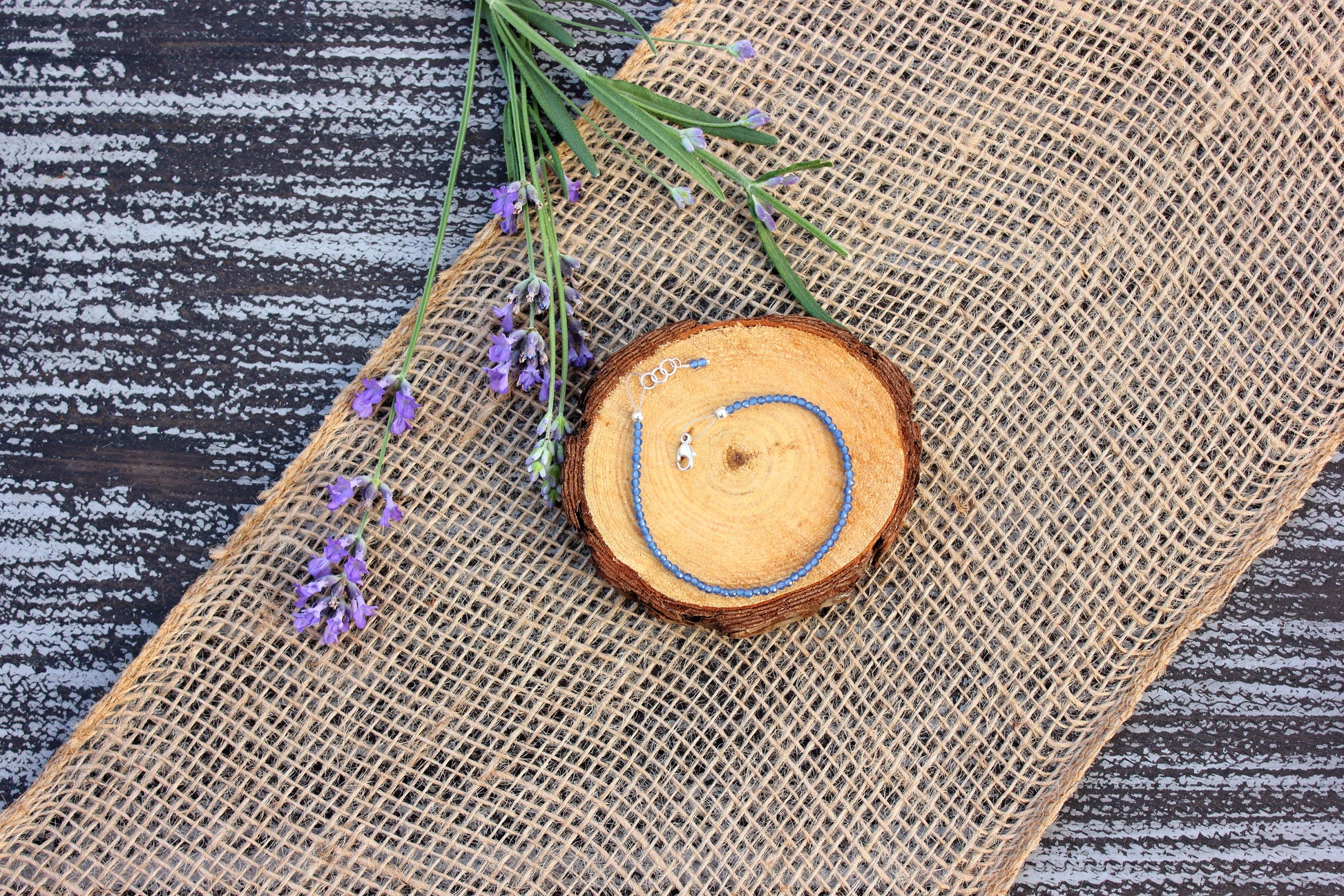 Wooden coaster with a ring on a burlap surface with lavender flowers