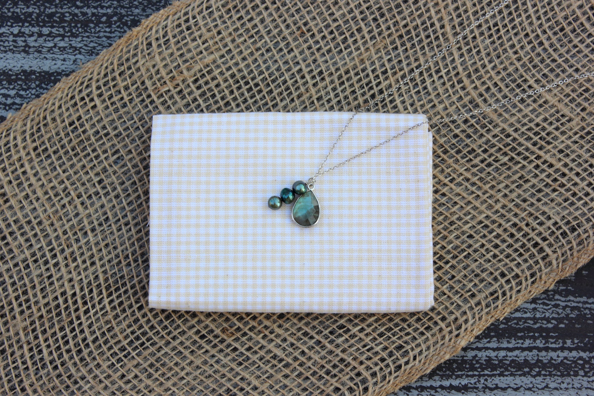 Necklace with pendant on a white card against a textured brown background