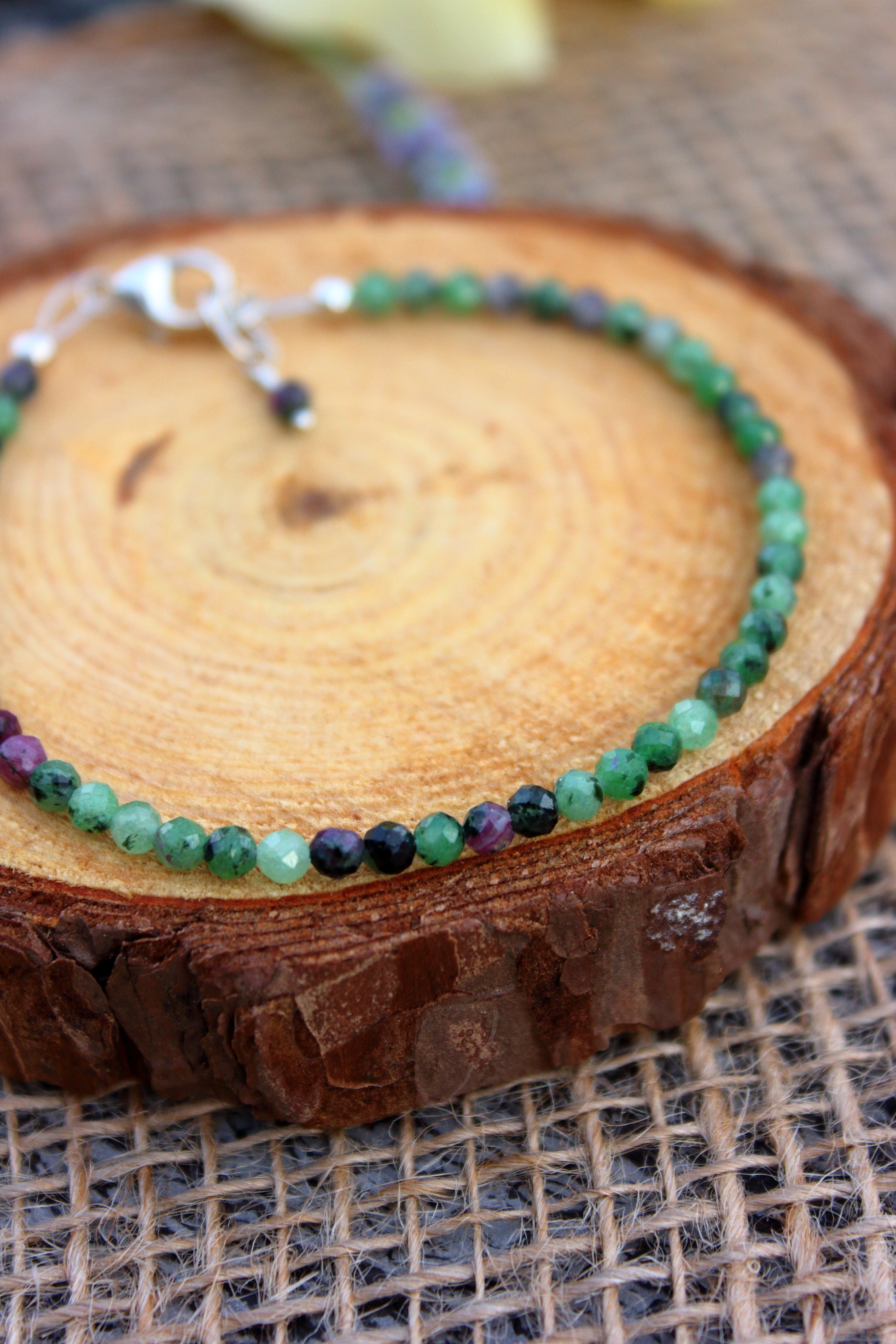 Bracelet with green and purple beads on a wooden surface