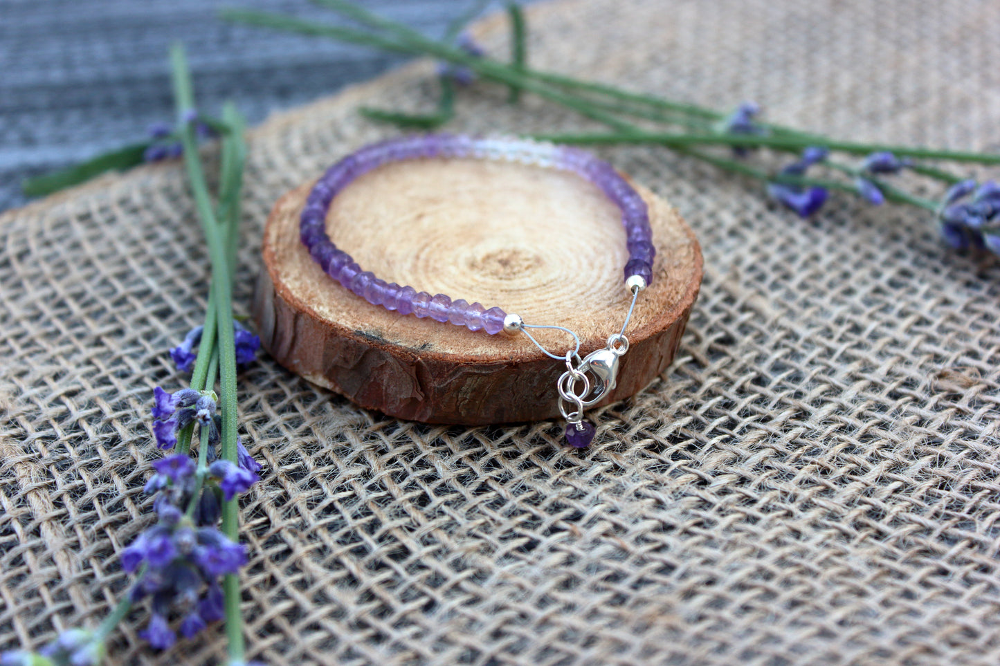 Amethyst bracelet on a wooden coaster with lavender flowers