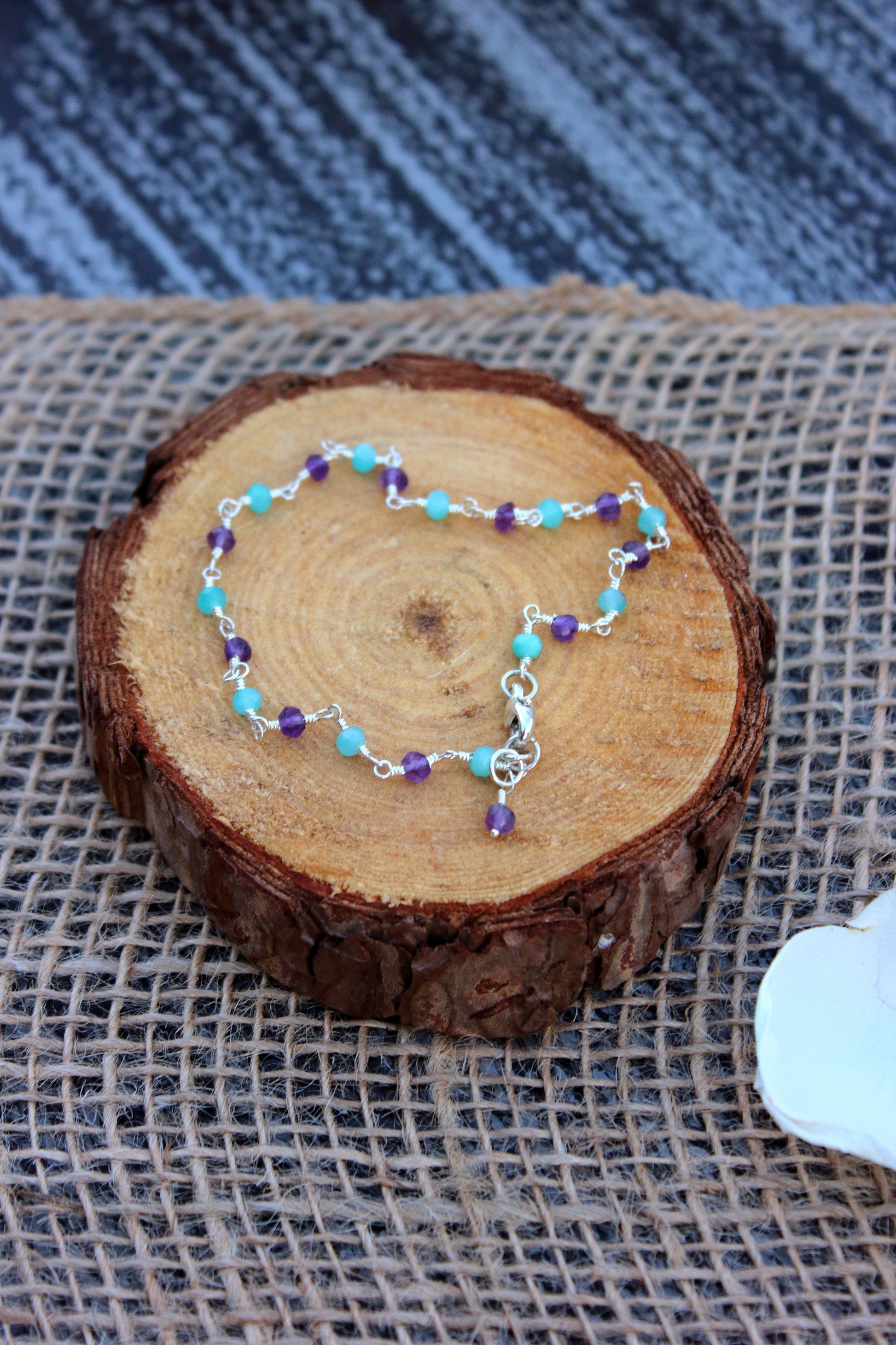 Bracelet with colorful beads on a wooden log
