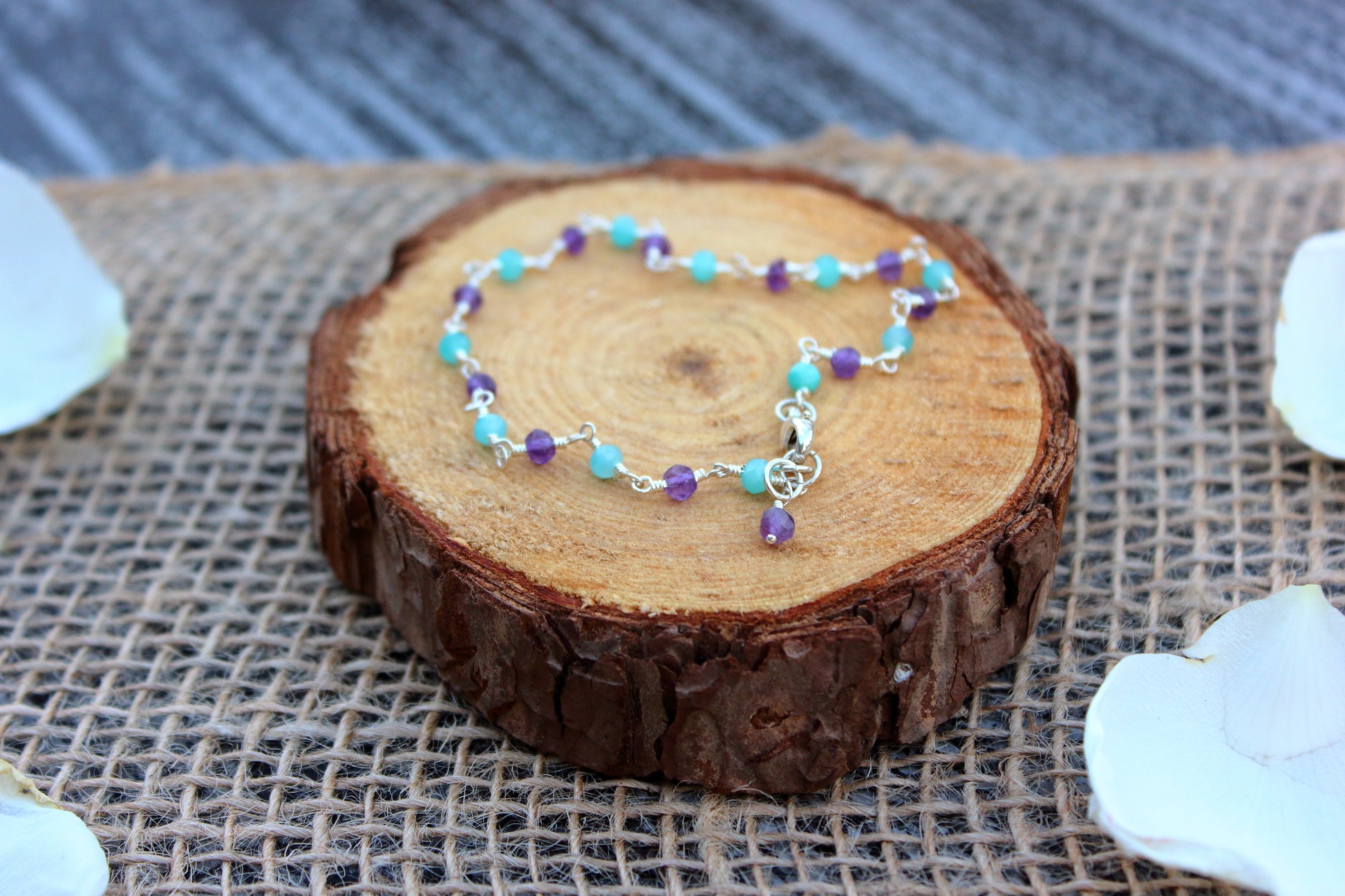 Bracelet with colorful beads on a wooden slice with a burlap background