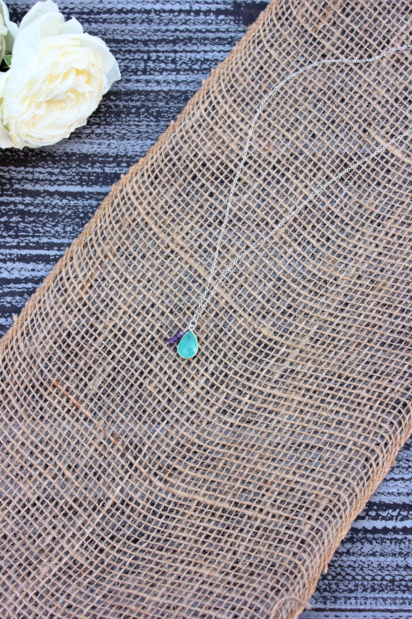 Burlap fabric with a small blue stone on a textured surface