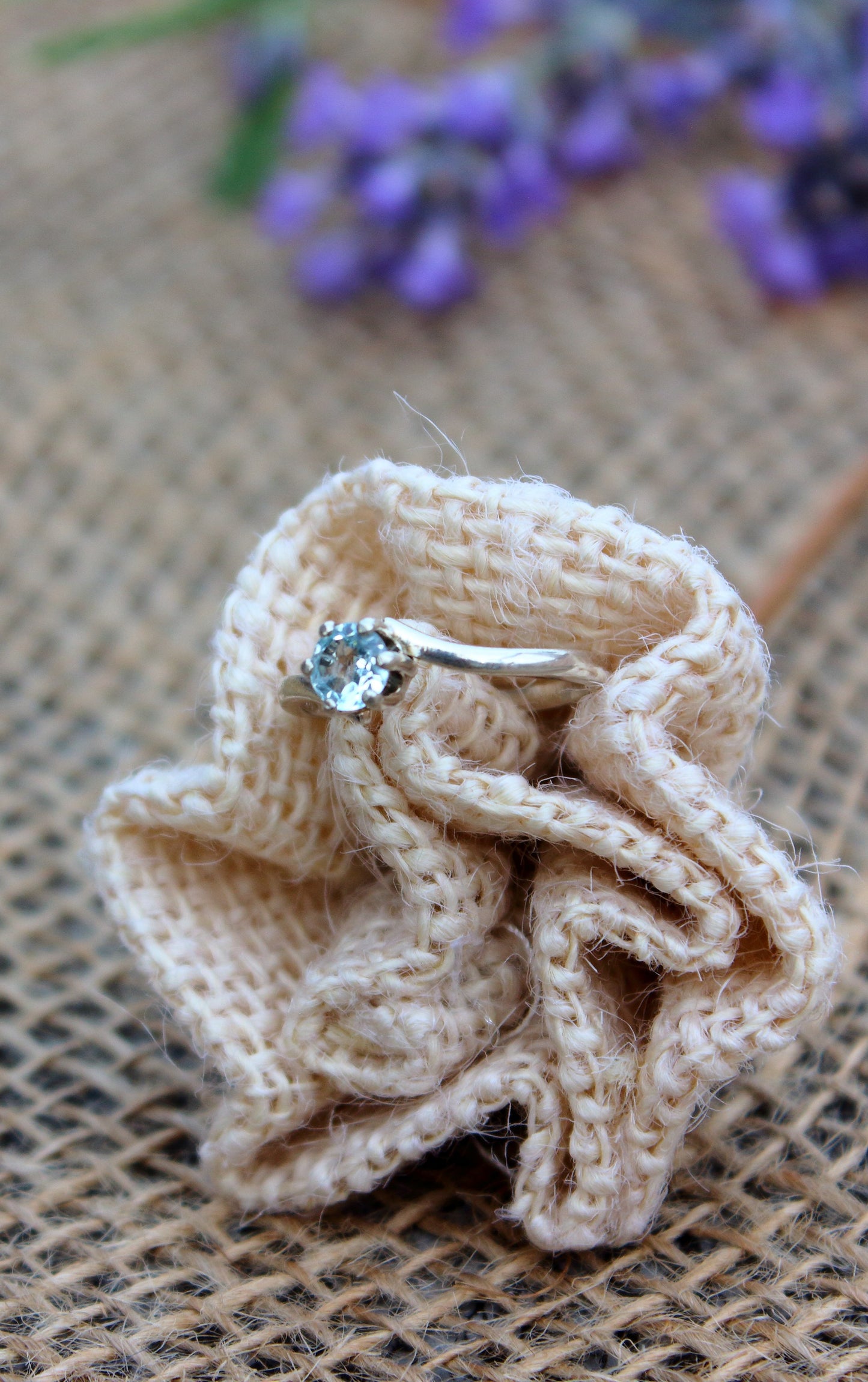 Floral arrangement with a diamond ring on a textured surface