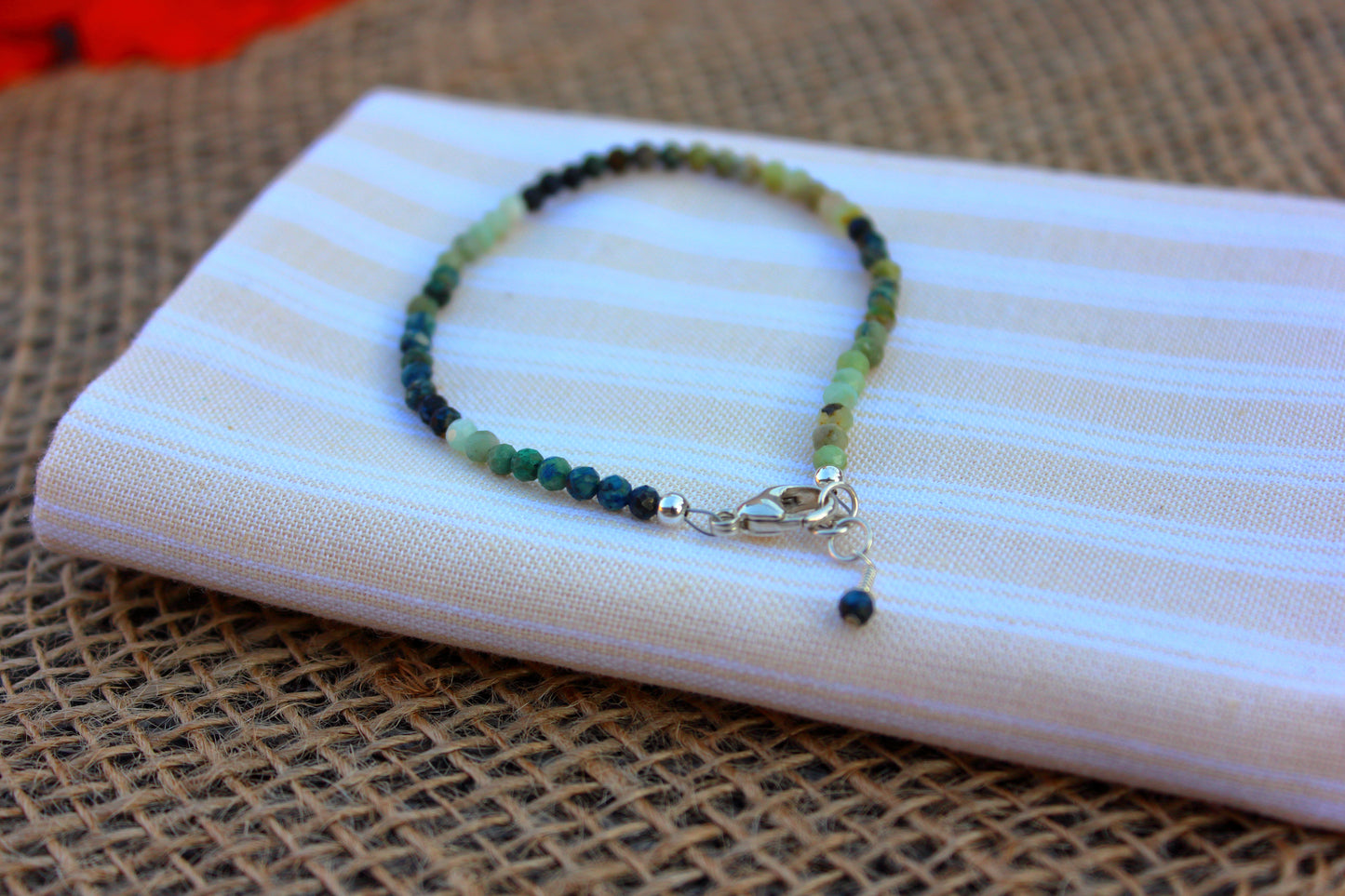 Beaded bracelet on a striped fabric with a textured surface