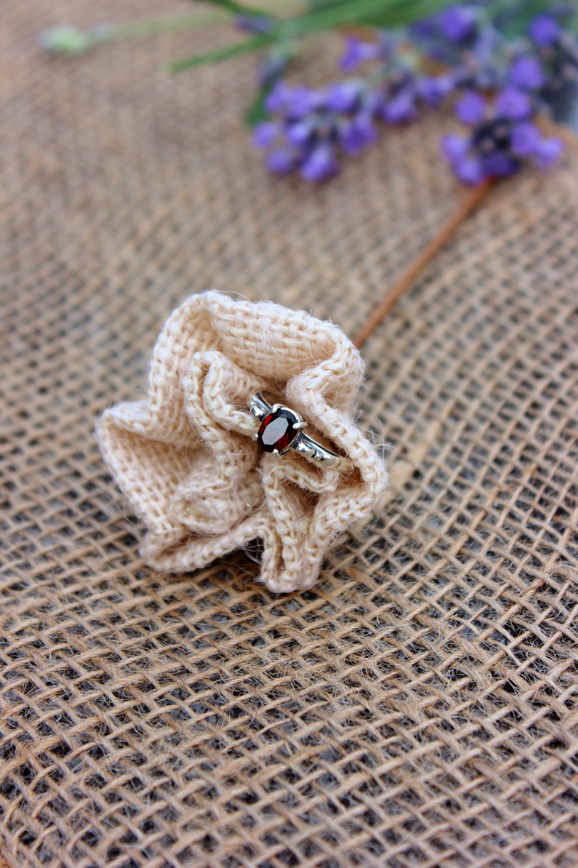 Crocheted flower with a ring on a textured fabric background