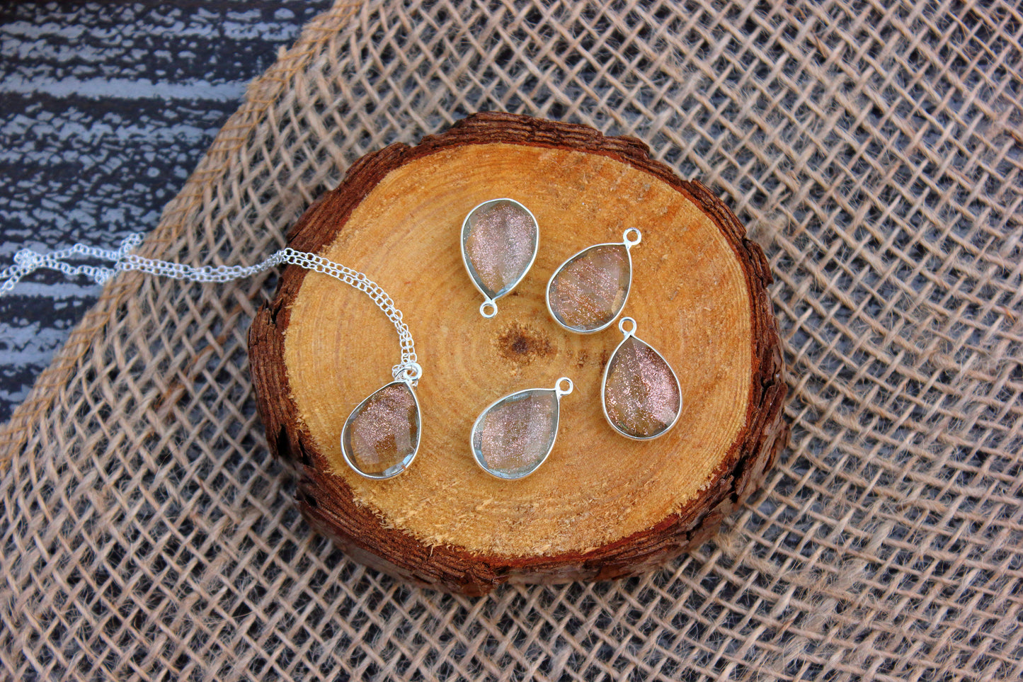 Jewelry set with teardrop-shaped pendants on a wooden surface