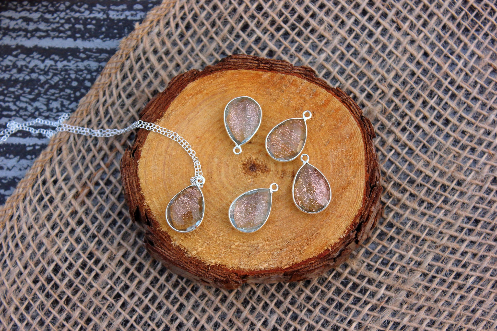 Jewelry set with teardrop-shaped pendants on a wooden surface