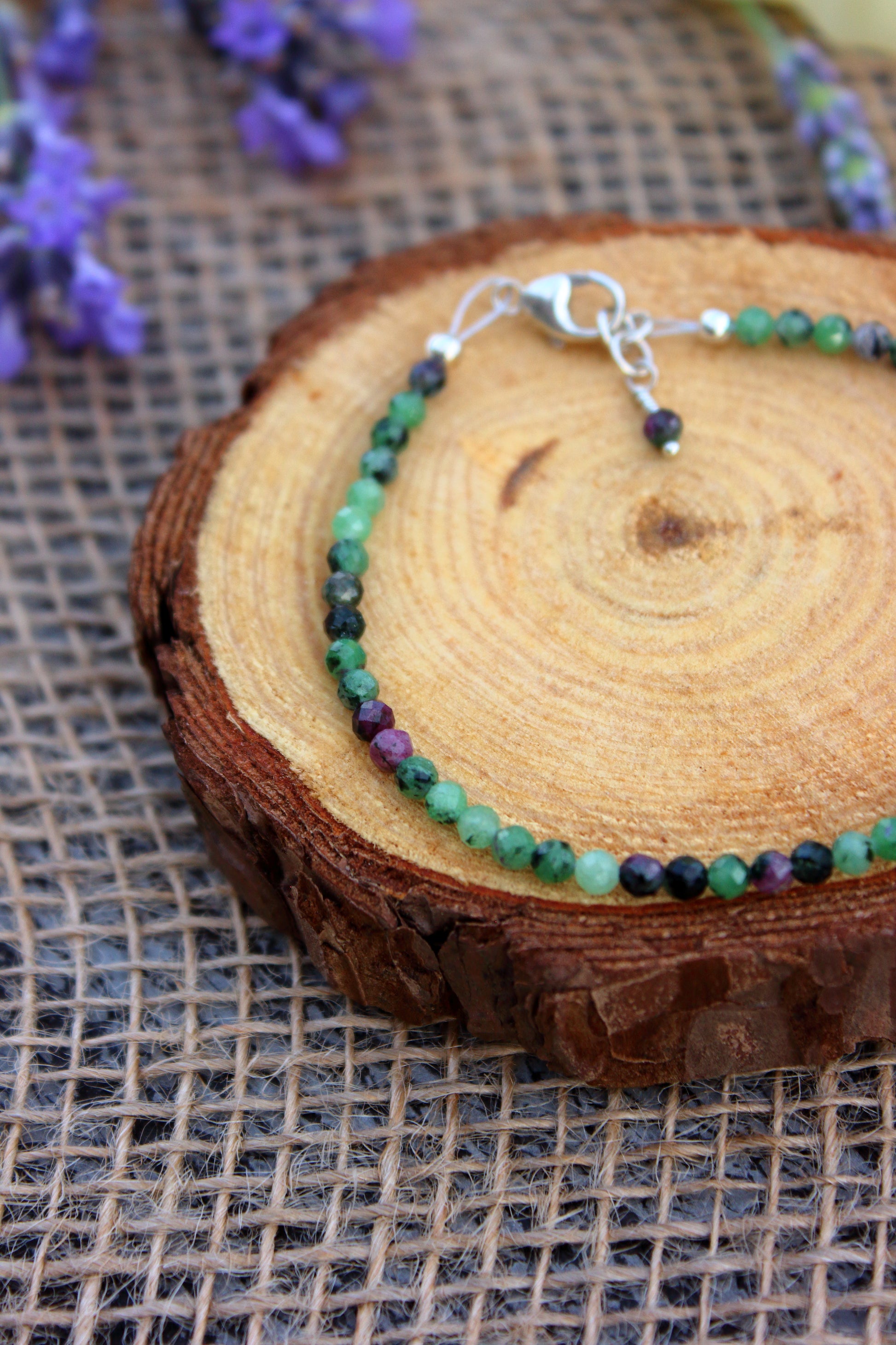 Bracelet with green and purple beads on a wooden surface